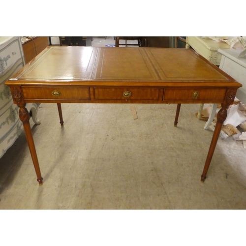 94 - A modern mahogany desk, the top set with a tooled brown hide scriber, over three drawers, raised on ... 