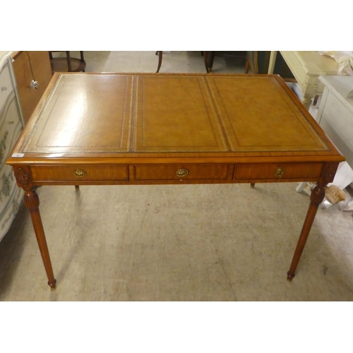 94 - A modern mahogany desk, the top set with a tooled brown hide scriber, over three drawers, raised on ... 