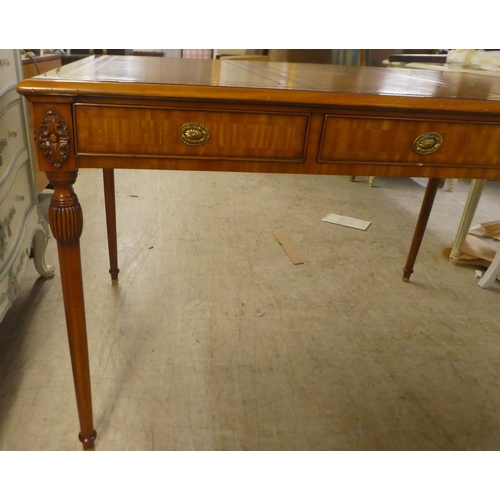 94 - A modern mahogany desk, the top set with a tooled brown hide scriber, over three drawers, raised on ... 