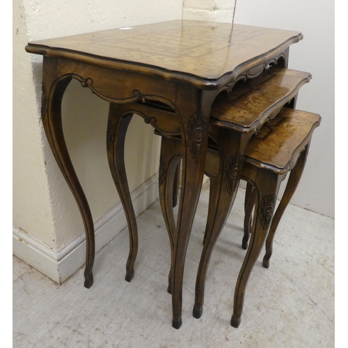 96 - A nesting set of three early 20thC beech and marquetry inlaid tables, raised on cabriole legs  large... 