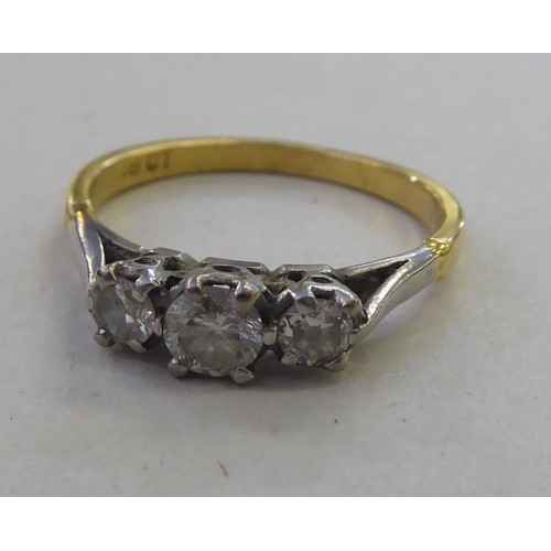 180 - An 18ct gold three stone, claw set diamond ring