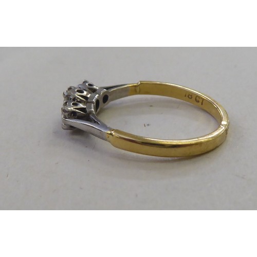 180 - An 18ct gold three stone, claw set diamond ring