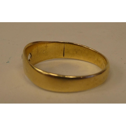 129 - A gold coloured metal ring, rubover set with a single diamond