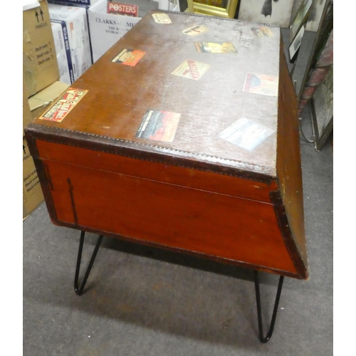 135 - A vintage suitcase table, finished in reinforced hide, bears various luggage labels, raised on steel... 