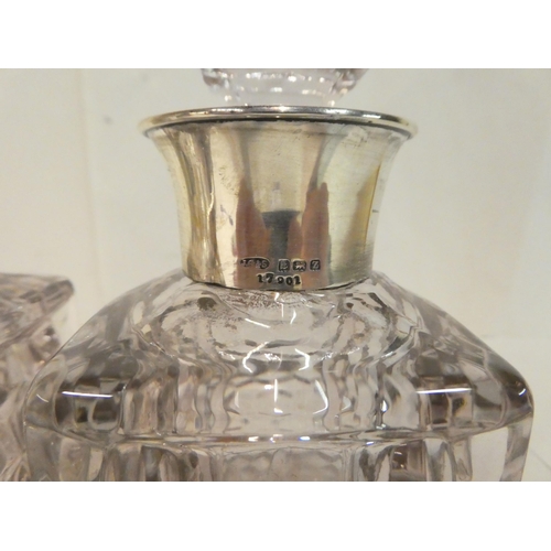 215 - Two moulded, shouldered, square glass decanters with silver collars  modern Birmingham marks