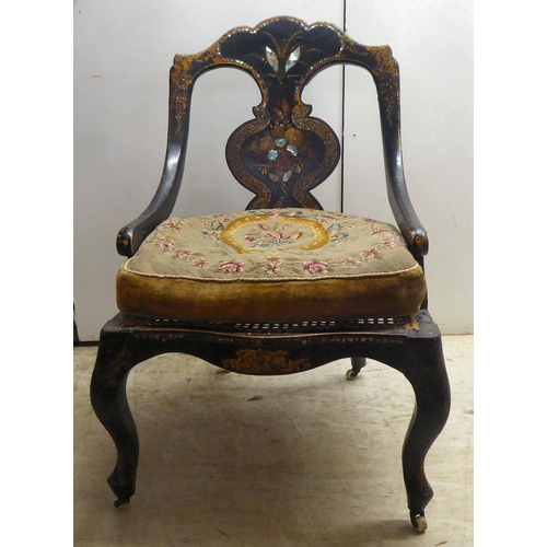 324 - A Regency black lacquered, overpainted, mother-of-pearl inlaid and gilded splat back nursing chair w... 