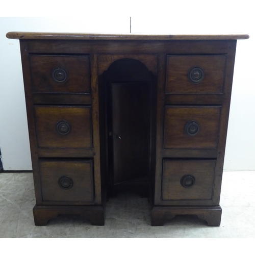 325 - A 20thC mahogany, one piece, six drawer, twin pedestal desk, raised on bracket feet  29