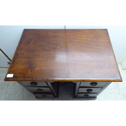 325 - A 20thC mahogany, one piece, six drawer, twin pedestal desk, raised on bracket feet  29