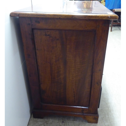 325 - A 20thC mahogany, one piece, six drawer, twin pedestal desk, raised on bracket feet  29