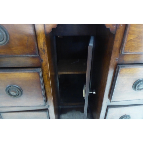 325 - A 20thC mahogany, one piece, six drawer, twin pedestal desk, raised on bracket feet  29