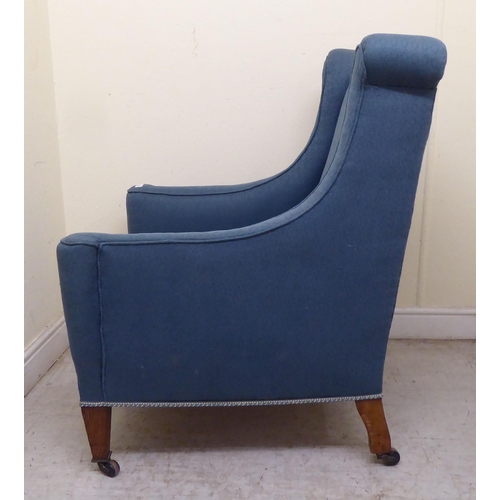 347 - A 1920s and later blue fabric upholstered, enclosed armchair, raised on tapered oak forelegs and cas... 