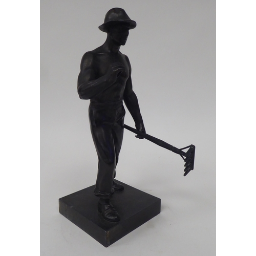 86 - An early 20thC Continental bronze effect artisan figure, holding a rake, on a stone plinth  10.5