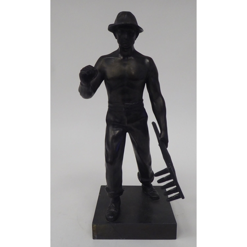 86 - An early 20thC Continental bronze effect artisan figure, holding a rake, on a stone plinth  10.5
