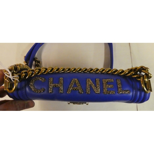 110 - A Chanel electric blue leather handbag with decorative metal mounts and chain