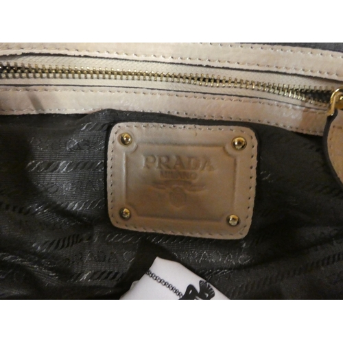 115 - A Prada butterscotch coloured leather handbag with dust cover; and a Louis Vuitton gold coloured seq... 