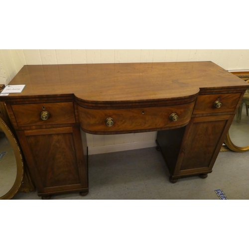 161 - A mid Victorian mahogany one-piece break bow front serving sideboard with three frieze drawers, over... 