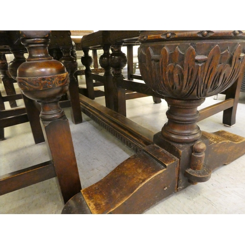 87 - A mid 20thC oak refectory style dining table, raised on opposing baluster carved uprights and platfo... 
