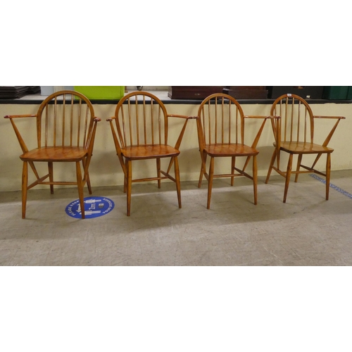 98 - A set of four Ercol stained beech and elm framed hoop and spindled back open arm chairs, the solid s... 