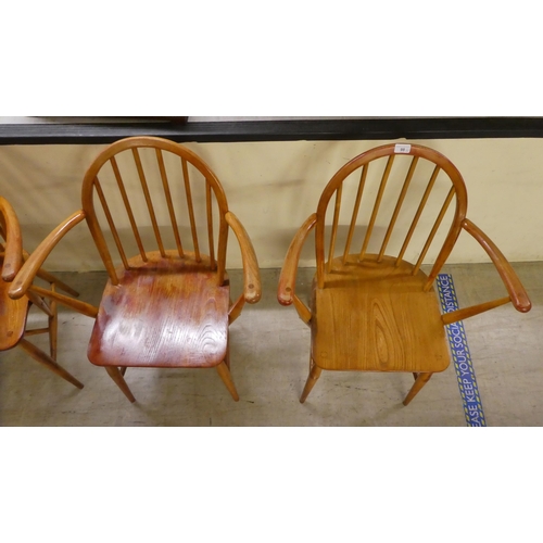 98 - A set of four Ercol stained beech and elm framed hoop and spindled back open arm chairs, the solid s... 