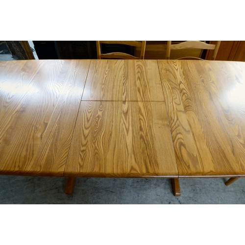 42 - An Ercol elm dining table, raised on planked supports  29
