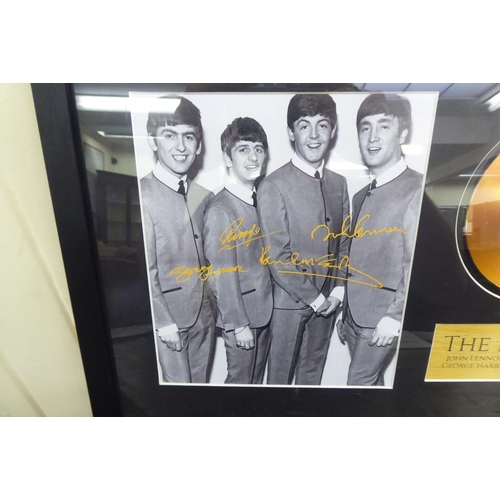 43 - A promotional photograph, featuring The Beatles and another in the centre of a gilded 45rpm disc, in... 