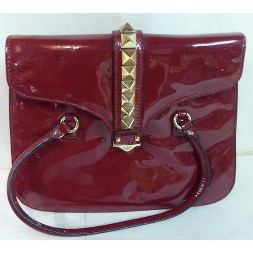 72 - Various handbags: to include a red patent example, ornamented with metal studs; a bottle green paten... 