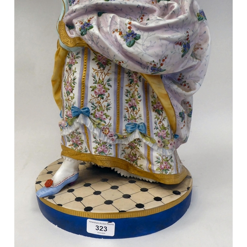 323 - A late 19thC French ceramic figure, a fashionable young lady wearing a floral skirt with a powder bl... 