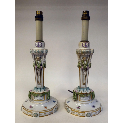 103 - A pair of Meissen porcelain table lamps, each featuring a candle style fitting, over a tapered, trif... 