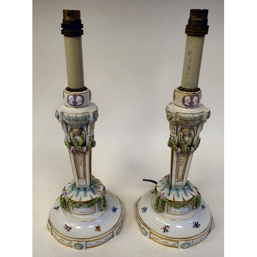 103 - A pair of Meissen porcelain table lamps, each featuring a candle style fitting, over a tapered, trif... 