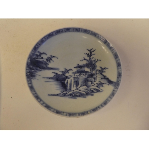 109 - A Nanking Cargo porcelain tea bowl and saucer, decorated in blue and white with buildings  bear... 