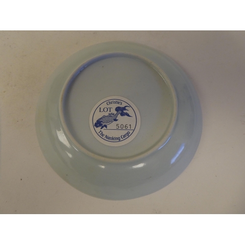 109 - A Nanking Cargo porcelain tea bowl and saucer, decorated in blue and white with buildings  bear... 