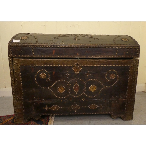 112 - An antique Continental, domed top trunk with decoratively stud finished and hide covered ornament wi... 