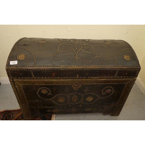 112 - An antique Continental, domed top trunk with decoratively stud finished and hide covered ornament wi... 