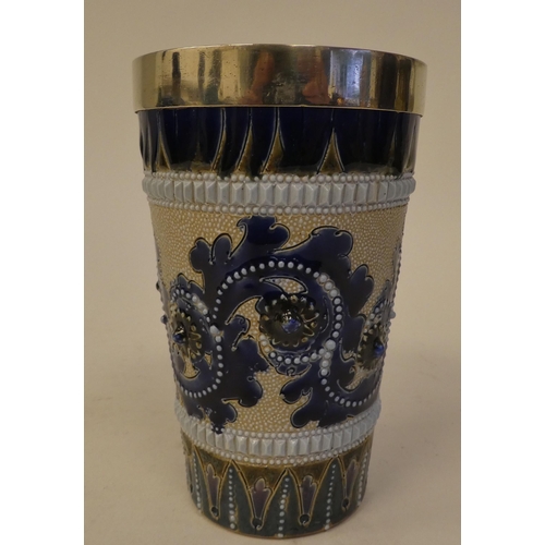 115 - A late 19thC Doulton Lambeth stoneware beaker, decorated in colours with applied ornament and a whit... 