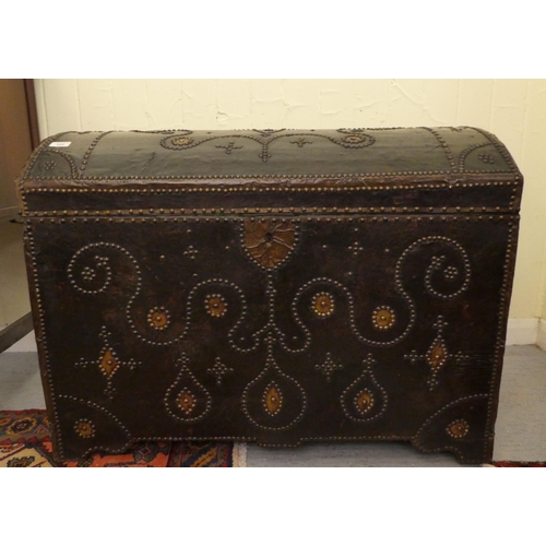 122 - An antique Continental, domed top trunk with decoratively stud finished and hide covered ornament, s... 