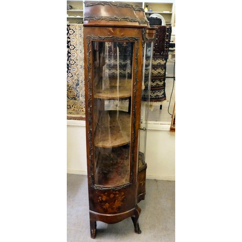 13 - A 19thC kingwood veneered, serpentine front vitrine with scrolled metal mounts, the platform cornice... 