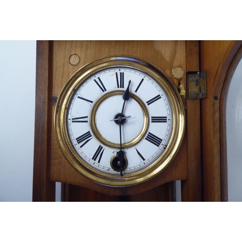 22 - An early 20thC Gothic inspired, ebonised and glazed, fruitwood cased Vienna design wall timepiece wi... 