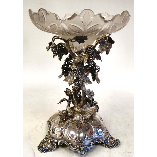 301 - A late Victorian/Edwardian silver plated table centrepiece, the ornately cast stand with fruiting vi... 