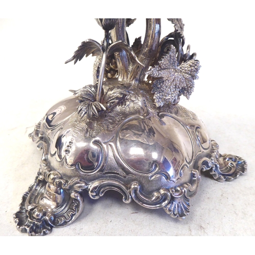 301 - A late Victorian/Edwardian silver plated table centrepiece, the ornately cast stand with fruiting vi... 