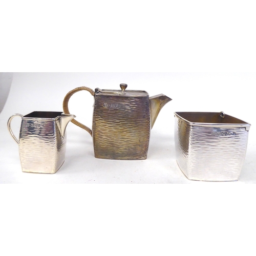 302 - A late Victorian Christopher Dresser three piece silver, bark effect bachelor's tea set of square, s... 