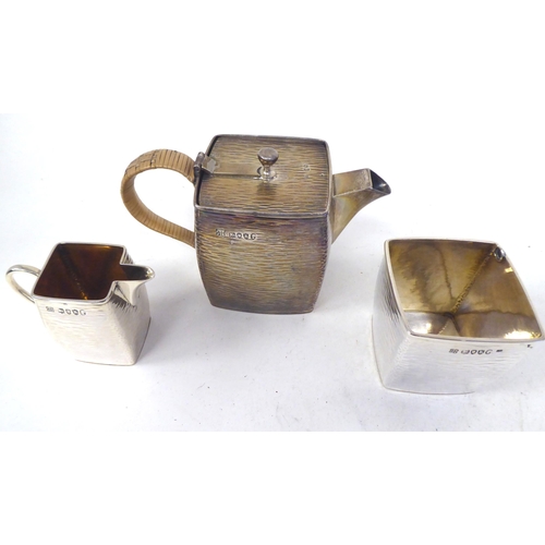 302 - A late Victorian Christopher Dresser three piece silver, bark effect bachelor's tea set of square, s... 