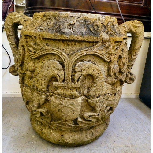 311 - An antique stone, twin handled urn, carved in relief with mythical birds, foliage and other ornament... 