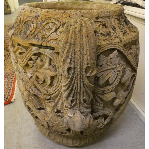 311 - An antique stone, twin handled urn, carved in relief with mythical birds, foliage and other ornament... 