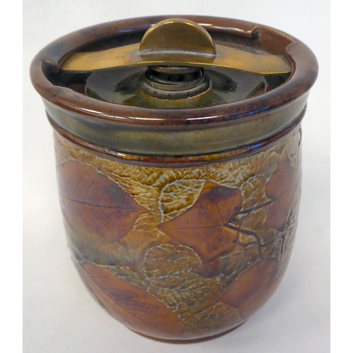 318 - A Royal Doulton stoneware tobacco jar, decorated in colours with autumnal leaves, the lid secured by... 