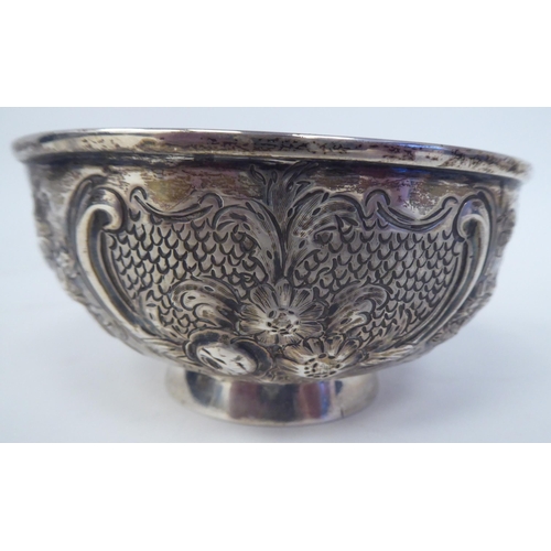 331 - A 19thC Irish silver footed bowl, embossed and chased with scrolls, vignettes and flora  bears ... 