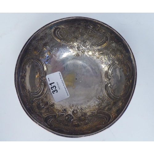 331 - A 19thC Irish silver footed bowl, embossed and chased with scrolls, vignettes and flora  bears ... 