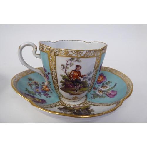 337 - A pair of late 19thC Austrian porcelain cups and saucers of oval outline, decorated in panels with f... 