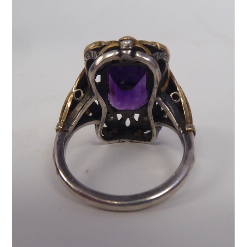 341 - A Sybil Dunlop bicoloured metal dress ring, set with an amethyst