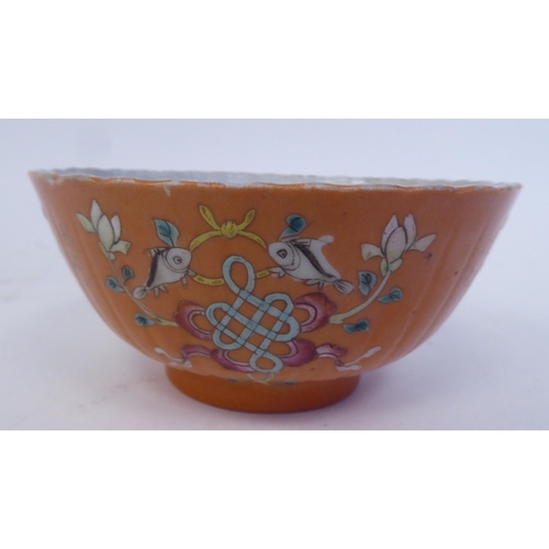 343 - A Chinese porcelain, ribbed, footed bowl, decorated in colours with stylised designs, on a pale ochr... 