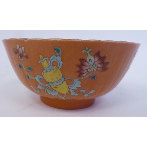 343 - A Chinese porcelain, ribbed, footed bowl, decorated in colours with stylised designs, on a pale ochr... 